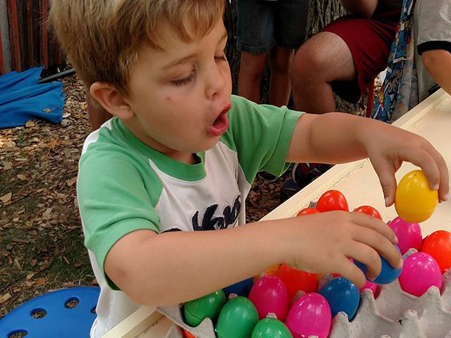 Boy with carton of colorful plastic eggs